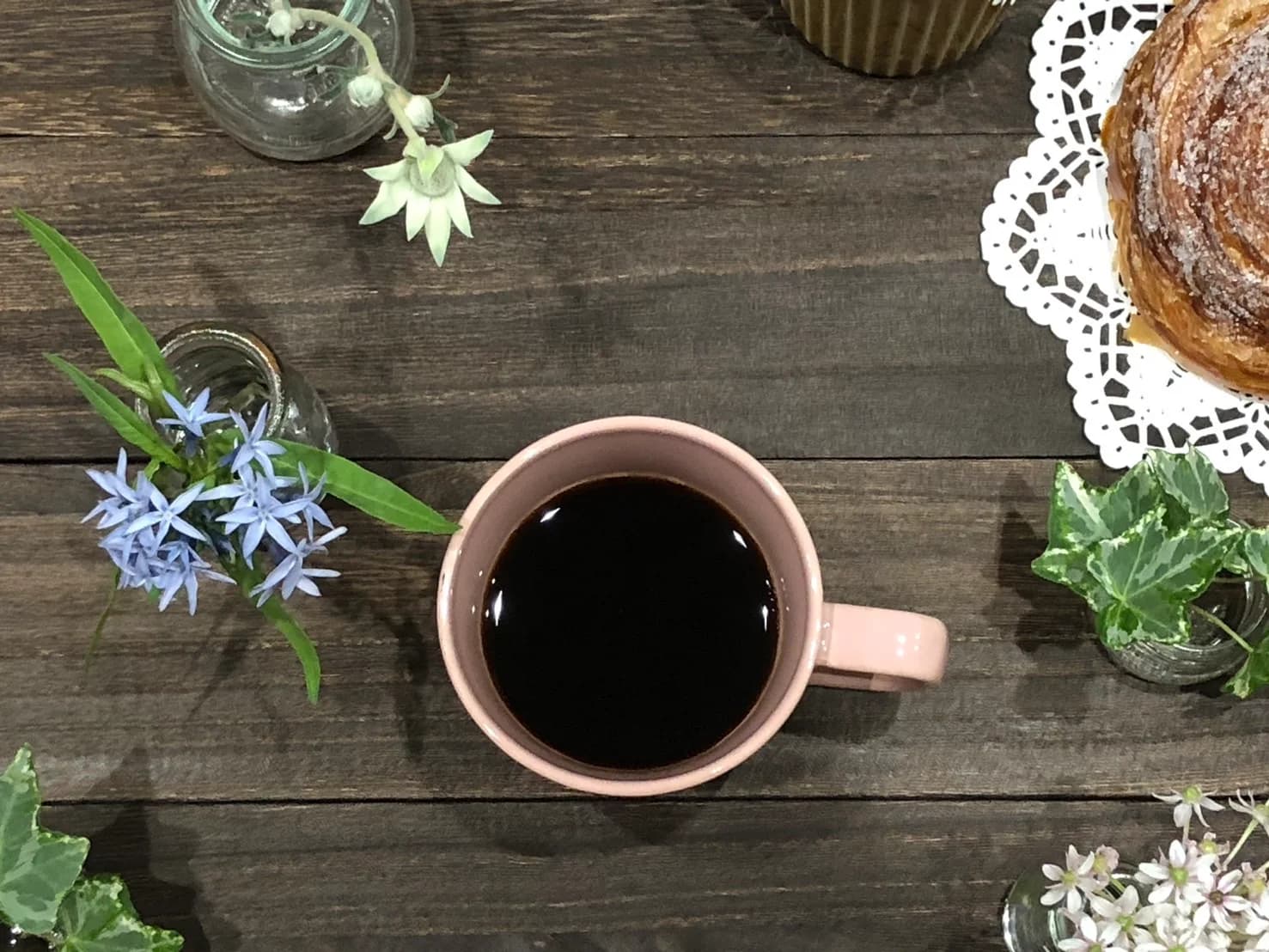 テーブルに並んだ mine coffee のコーヒーと花・焼き菓子